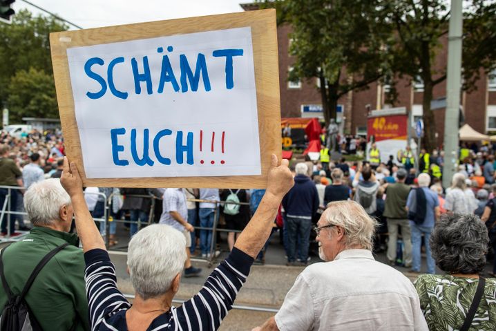 Eine Frau demonstriert gegen die Aufstellung der Marx-Statue vor der Zentrale der MLPD in Gelsenkirchen